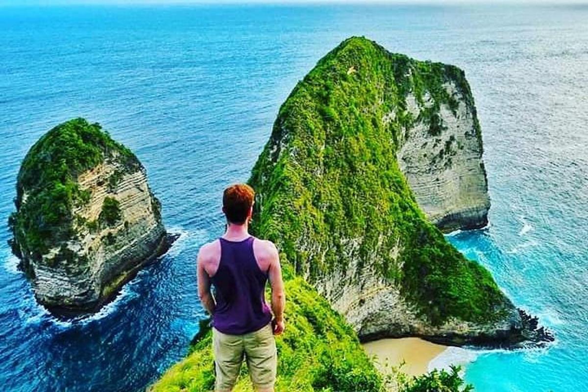 海を見下ろす山の頂上に立つ男性