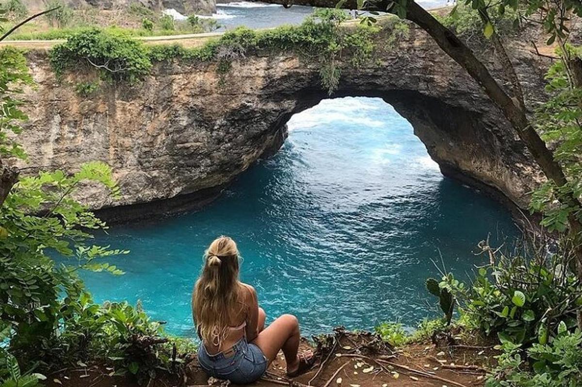 una donna seduta davanti a una grotta nell'acqua