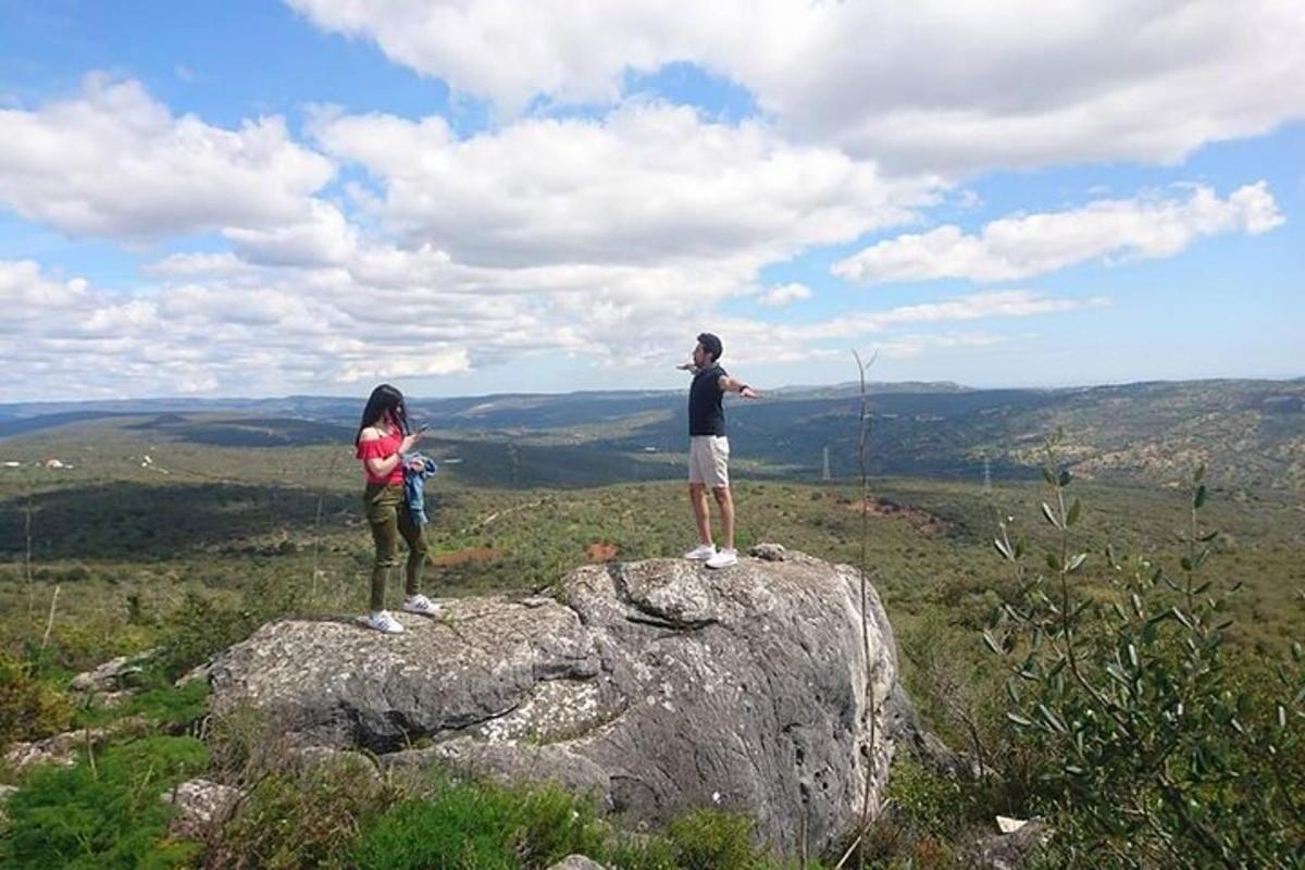 un paio di persone in piedi in cima a una roccia