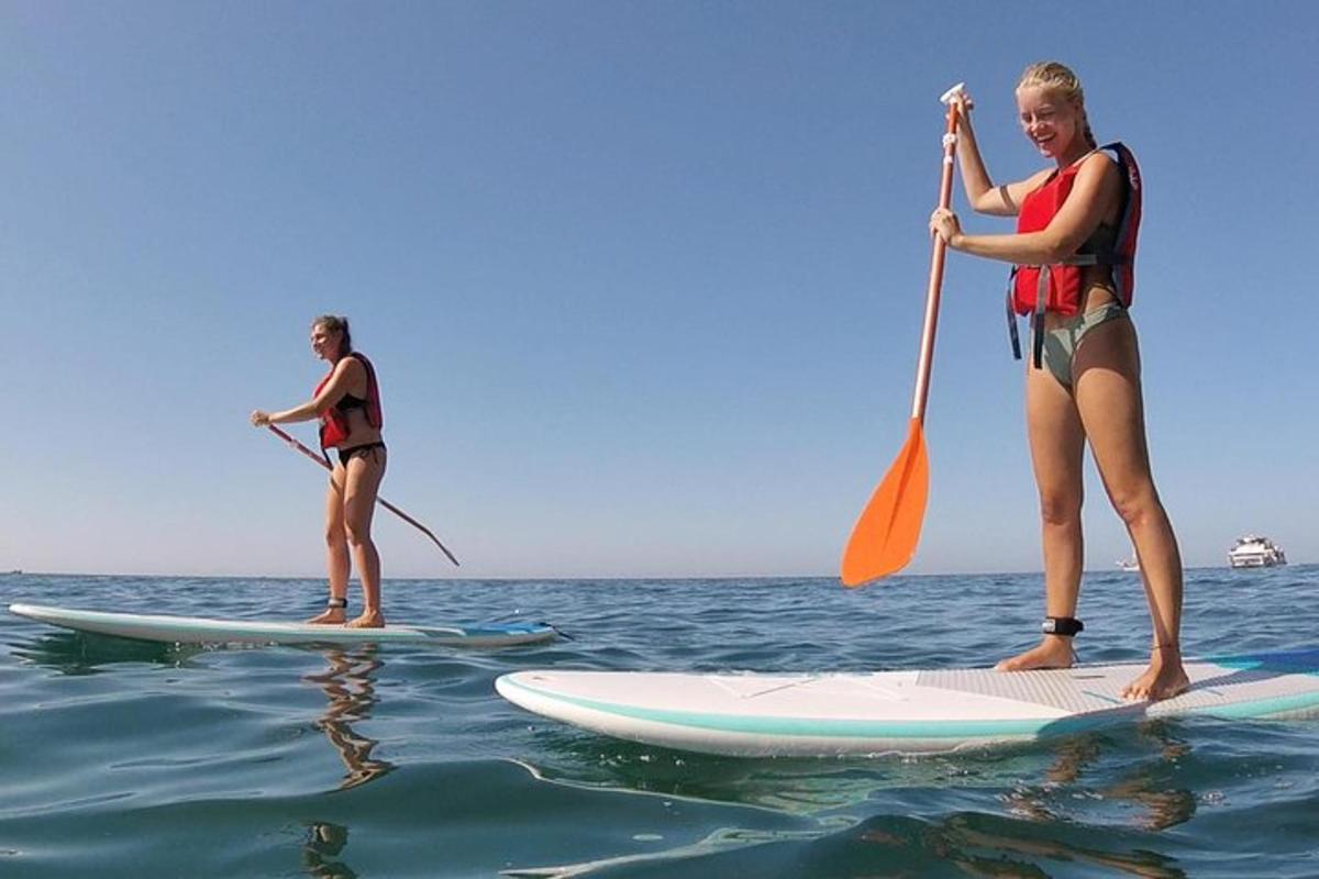 due donne sono in piedi su tavole da surf in acqua