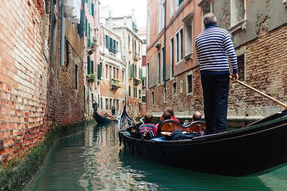 a man is standing in a gondola in a canal