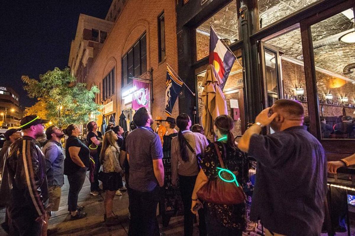 una multitud de personas caminando por una calle de noche