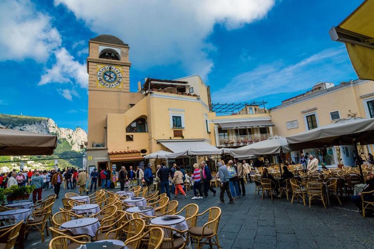 un grup de taules i cadires amb una torre del rellotge