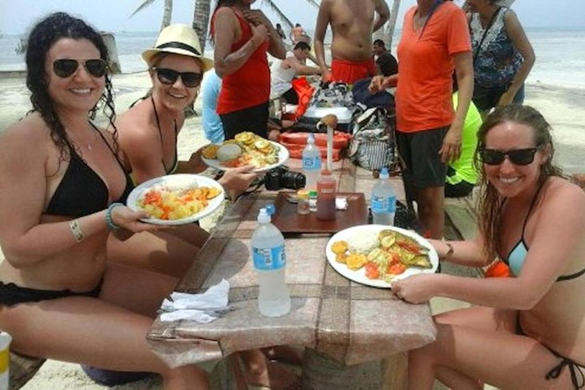 grupė moterų, sėdinčių prie stalo su lėkštėmis maisto