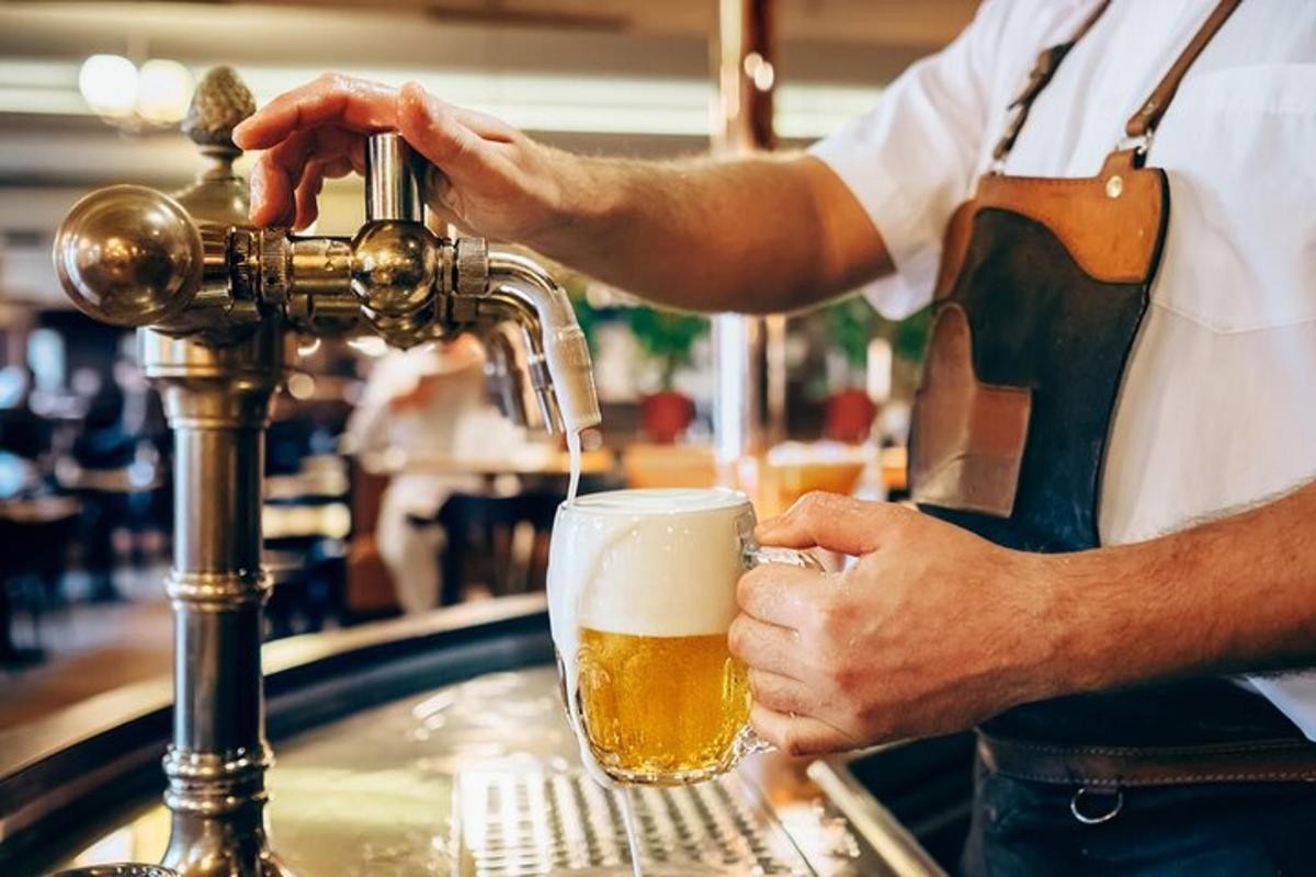 một người đàn ông đang rót bia vào ly