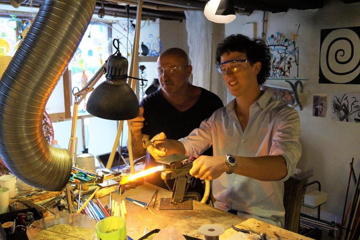 two men standing at a table working on a machine