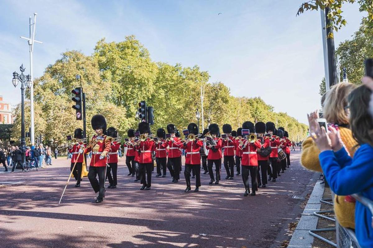 Una banda de música con uniforme rojo caminando por una calle