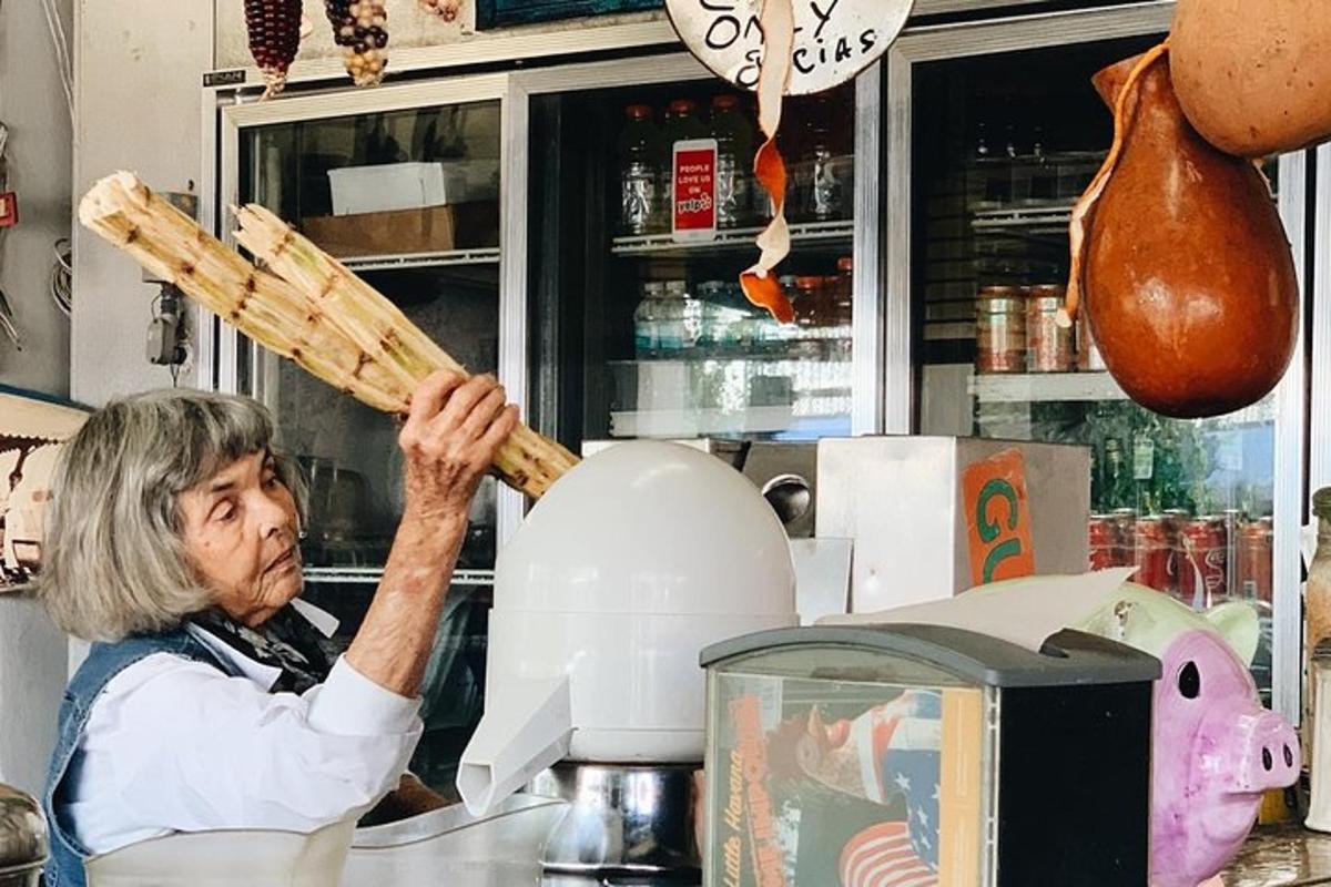 a woman is holding up a stick in a kitchen