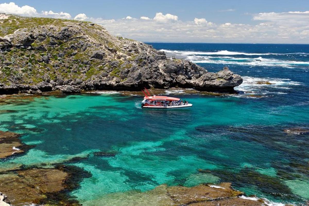 una barca nell'oceano accanto a una costa rocciosa
