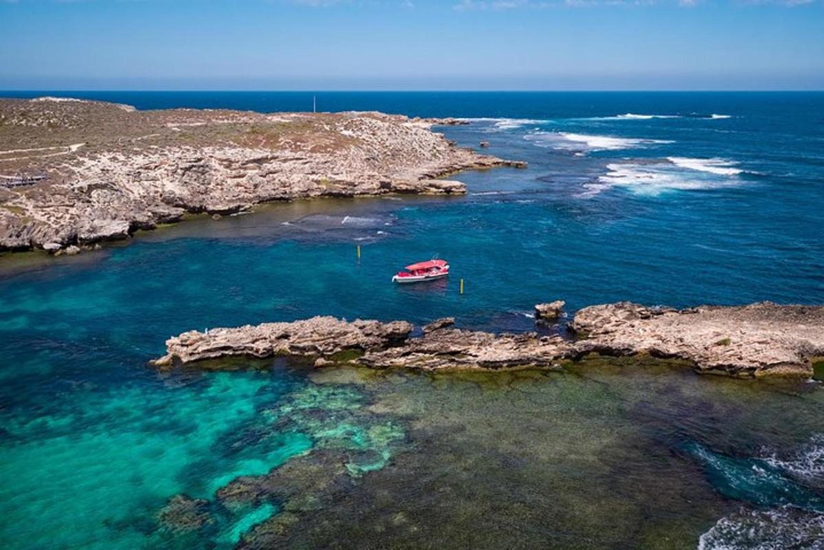 una barca in acqua vicino a una costa rocciosa