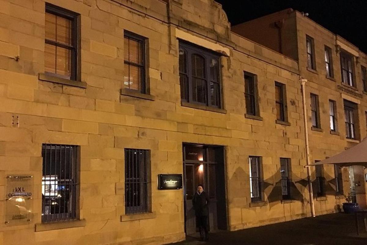 Un hombre parado frente a un edificio por la noche.