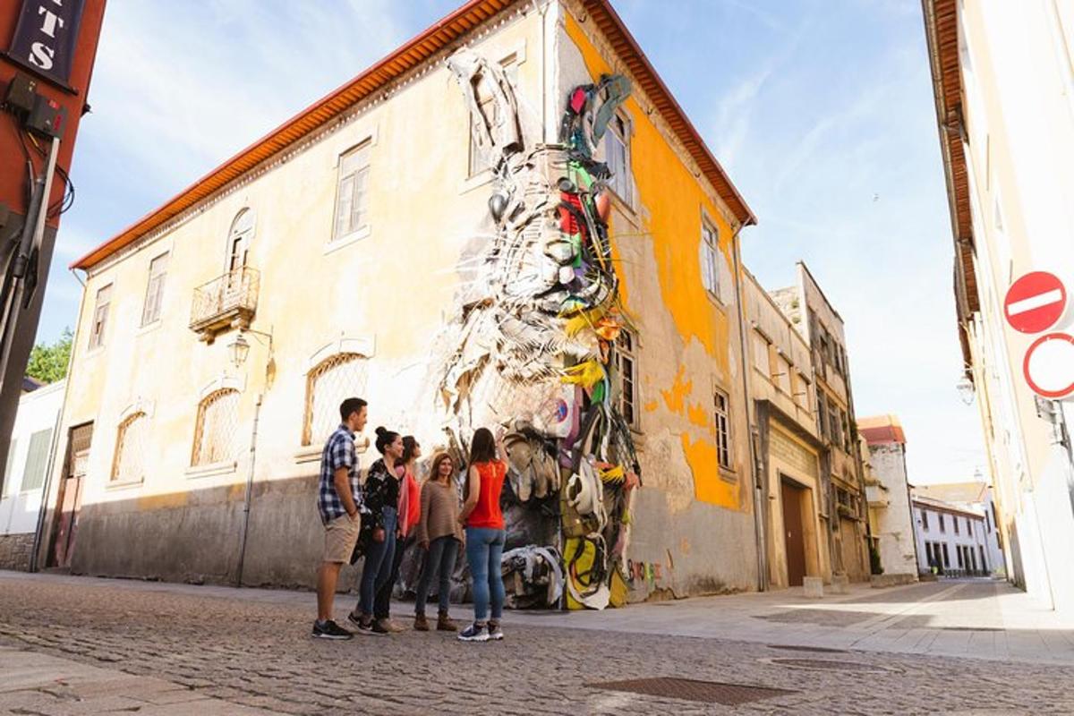 un grup de oameni care stau în fața unei picturi murale pe o clădire