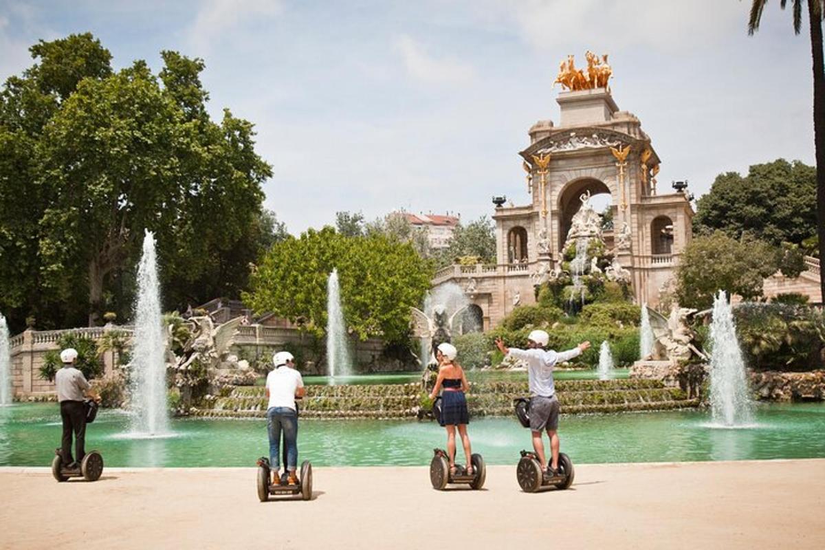 Skupina lidí jezdících na segwayích před fontánou