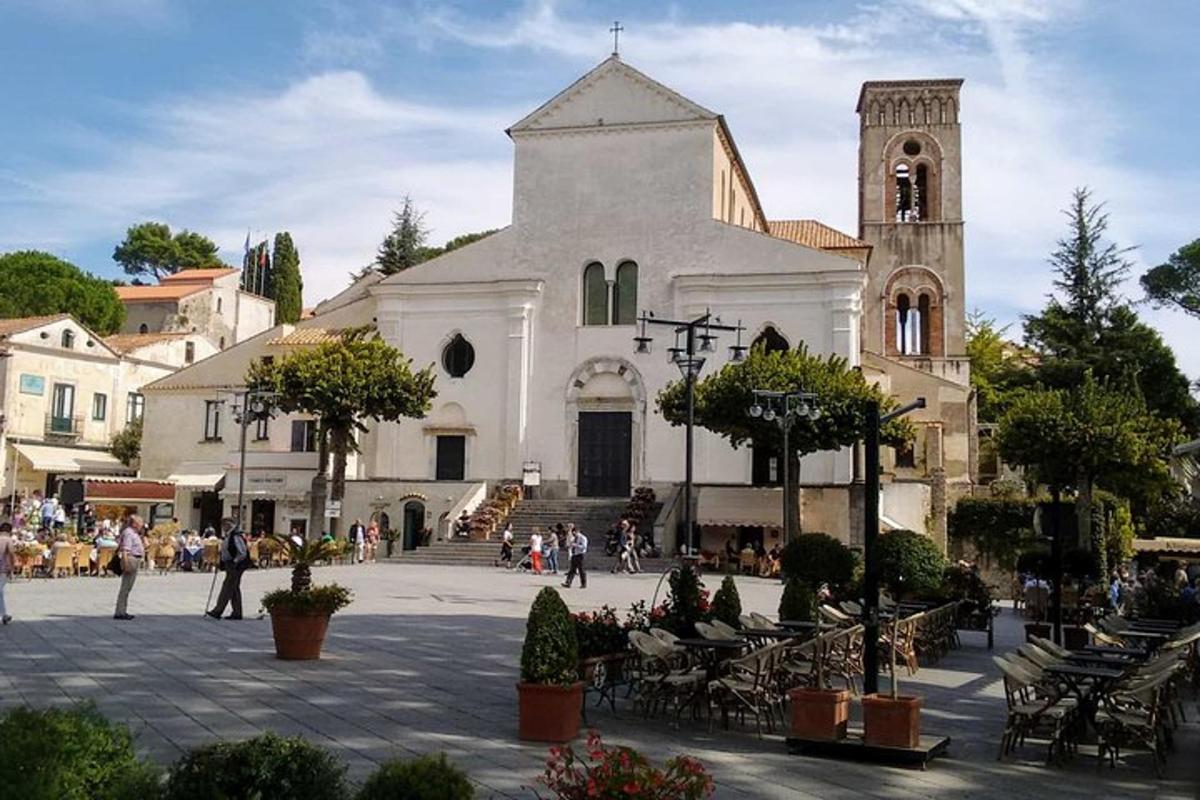 una grande chiesa bianca con una torre dell'orologio su una strada
