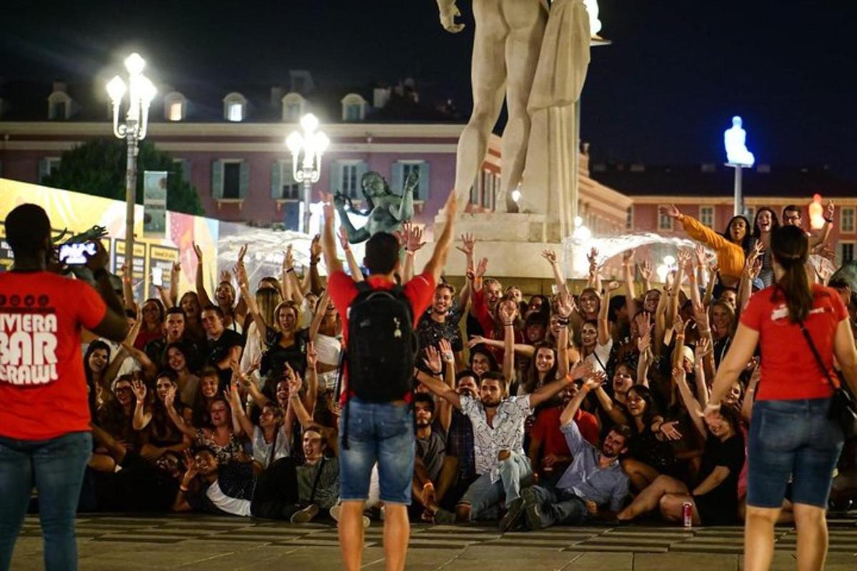una folla di persone che alzano le mani davanti a una statua