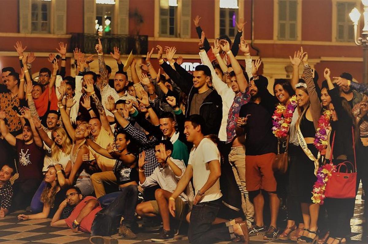 un folto gruppo di persone che applaudono e alzano le mani