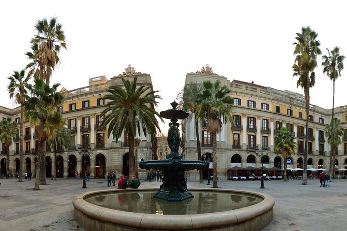 a fountain in front of a building with palm trees