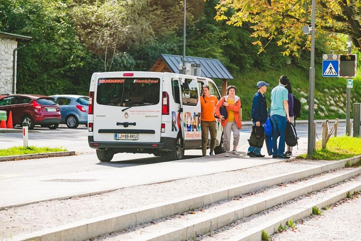 skupina lidí stojící vedle bílého autobusu