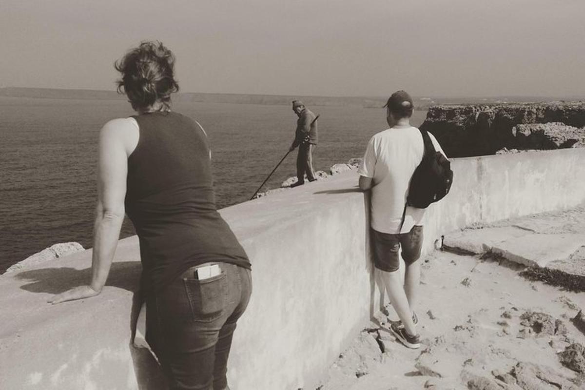dva lidé stojící na zdi s výhledem na oceán