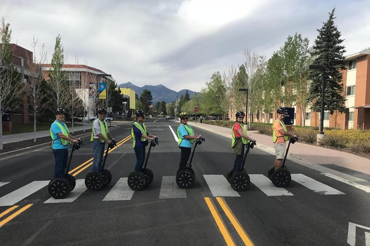 sekumpulan orang yang menaiki segway di jalan