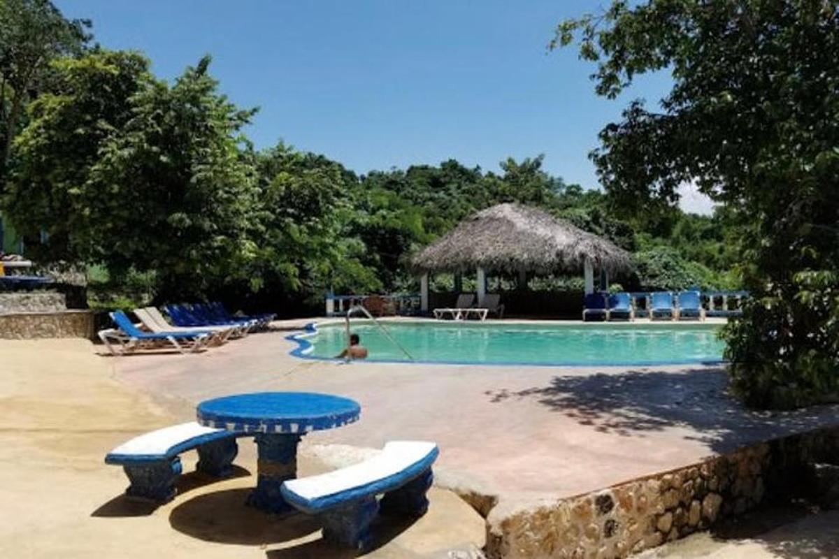 una piscina amb una taula i cadires blaves