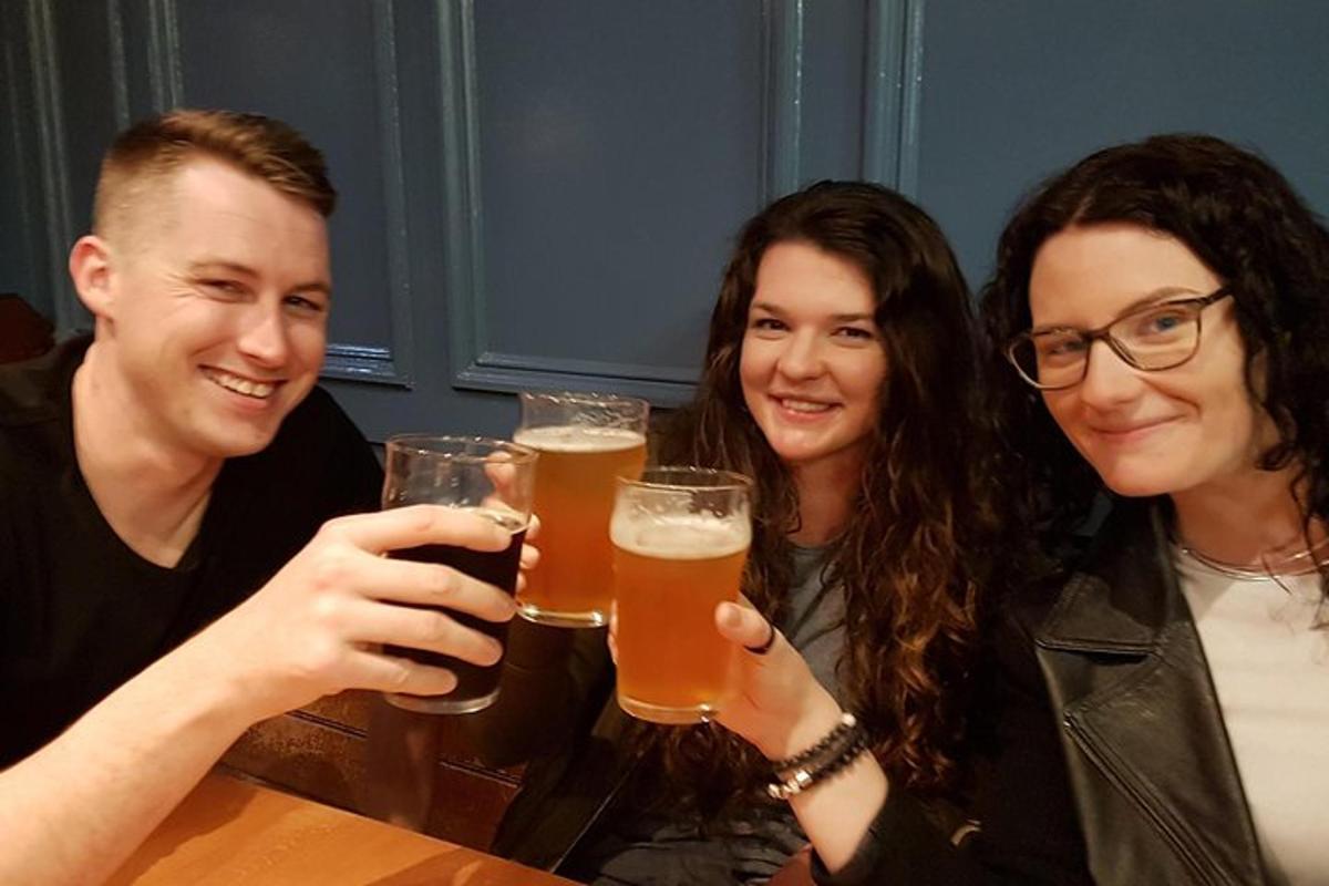 eine Gruppe von drei Personen, die Biergläser hochhalten