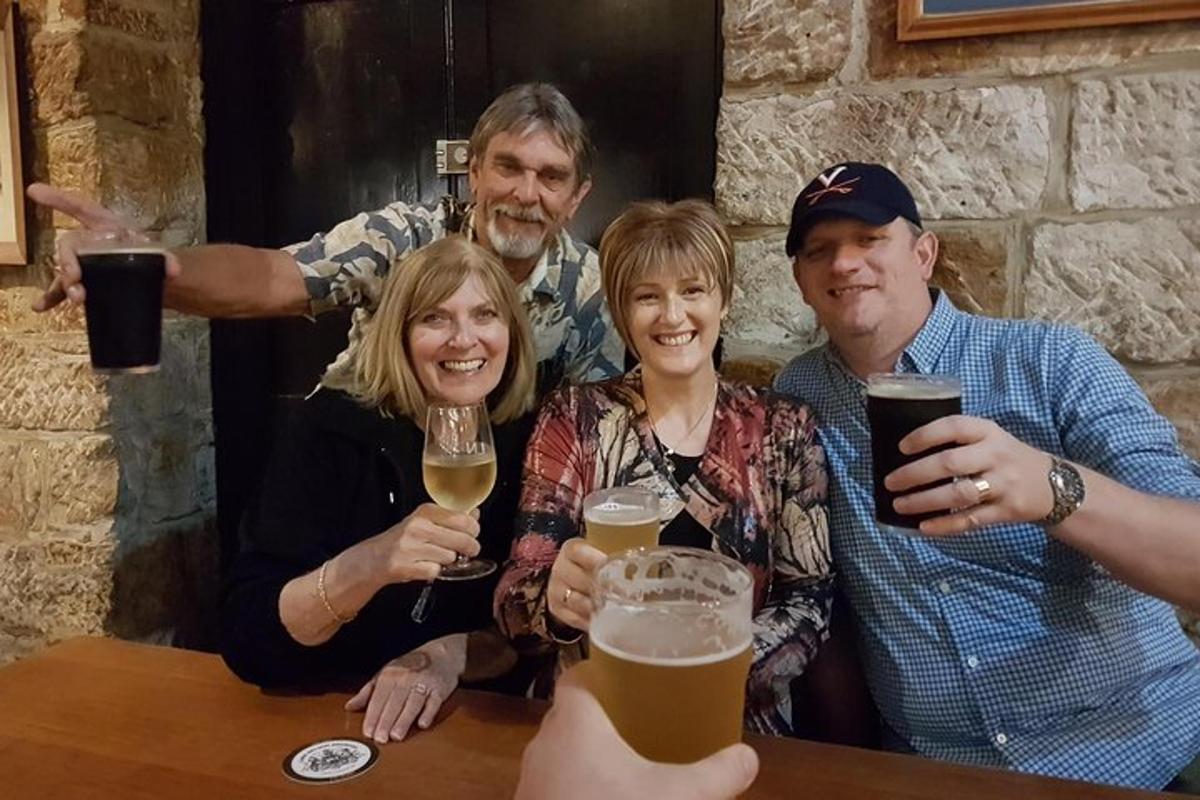 eine Gruppe von Menschen sitzt mit Gläsern Bier an einem Tisch