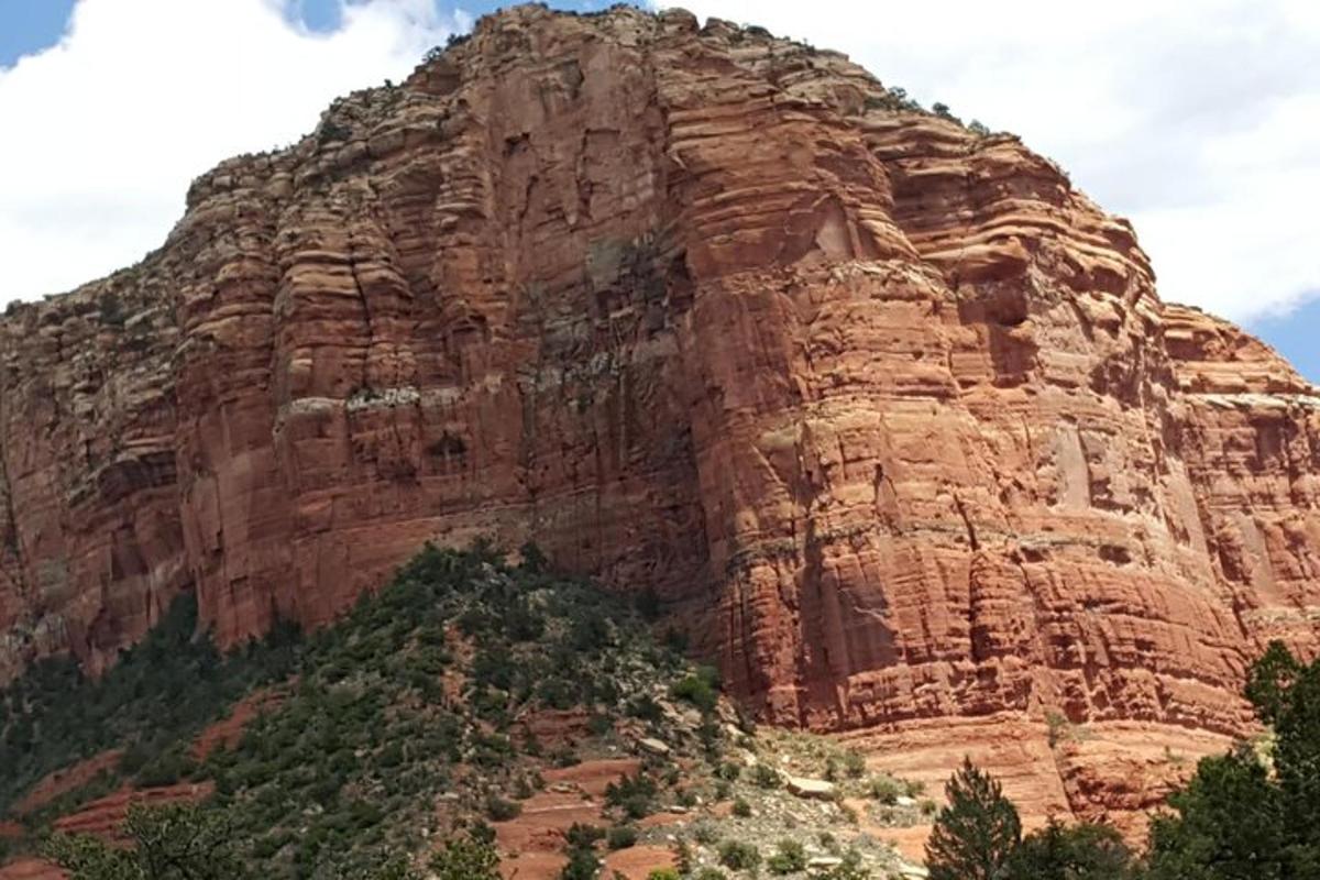 a large rocky mountain with trees in front of it