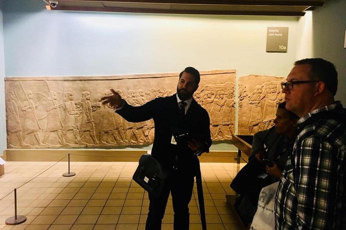 Un hombre con traje señalando un sarcófago en un museo.