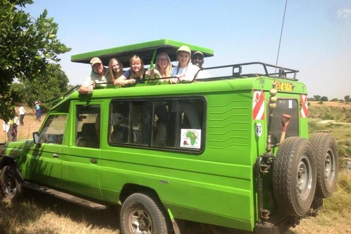 a group of people riding on the back of a green jeep