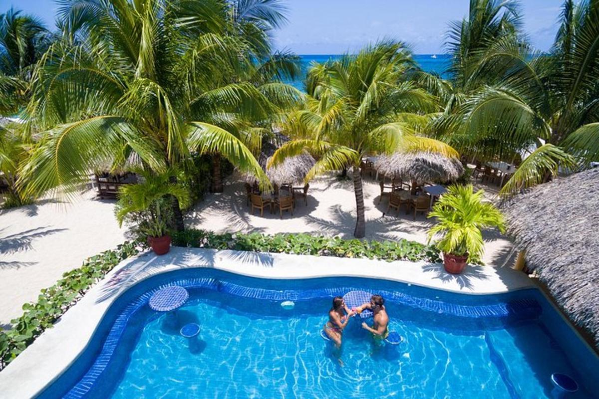 two people standing in the swimming pool at a resort