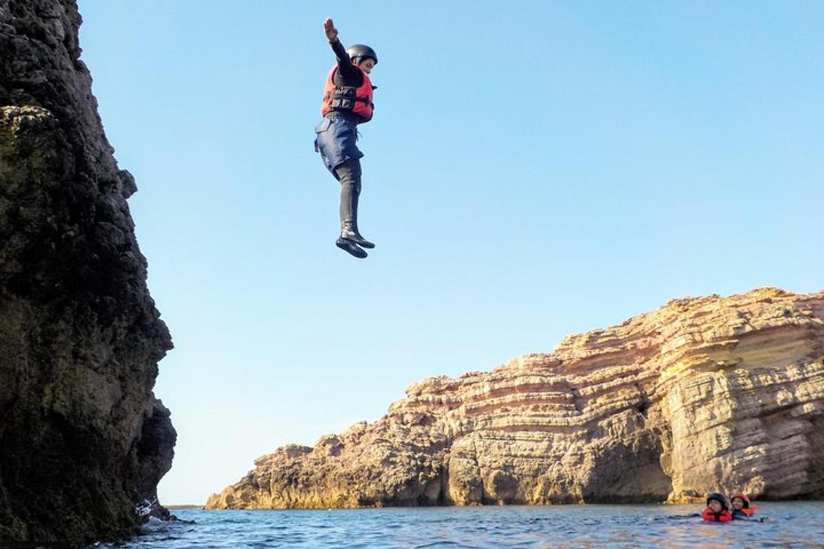 Ein Mann springt von einer Klippe ins Wasser