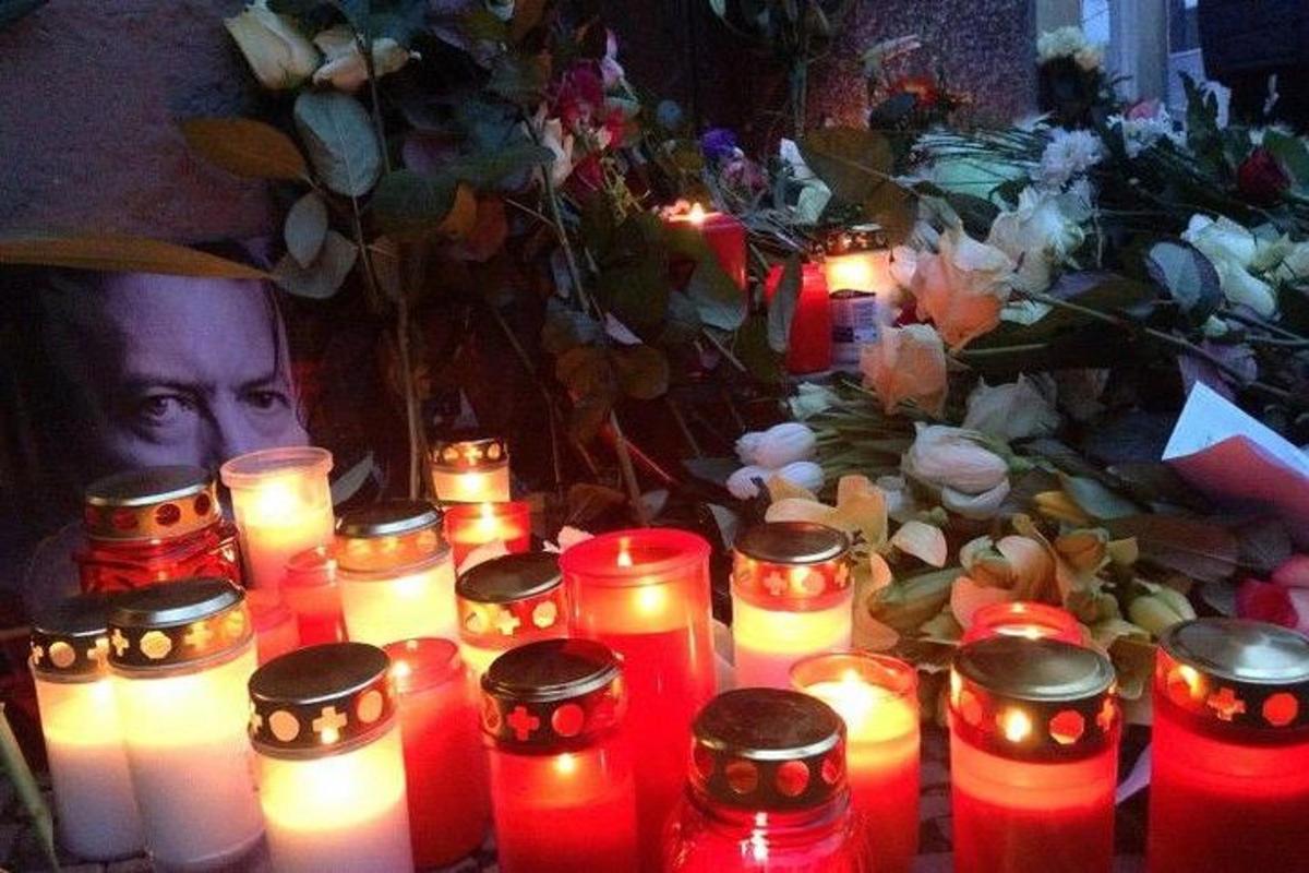 a group of candles in front of a table with flowers