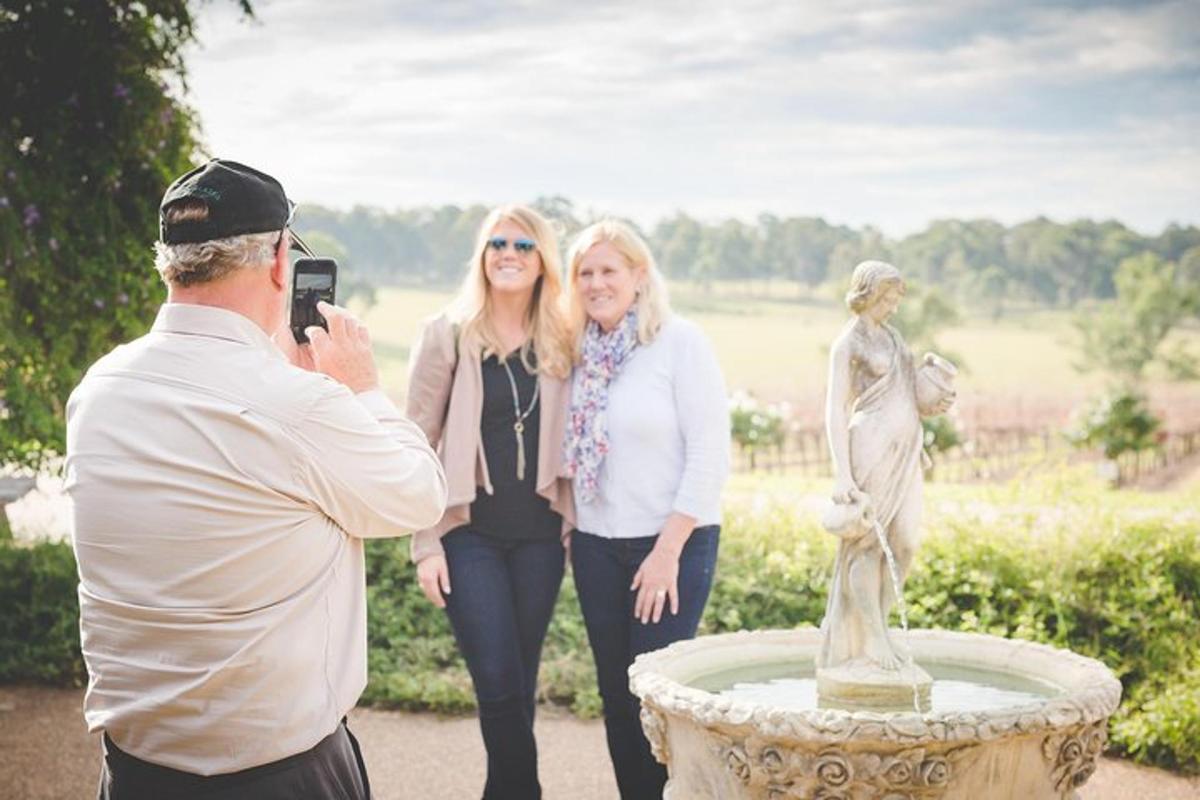a man taking a picture of two women standing next to a statue