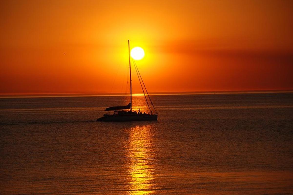 un veler a l'oceà a la posta de sol