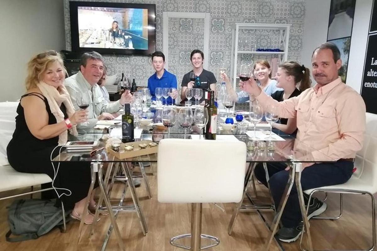 um grupo de pessoas sentadas ao redor de uma mesa com taças de vinho