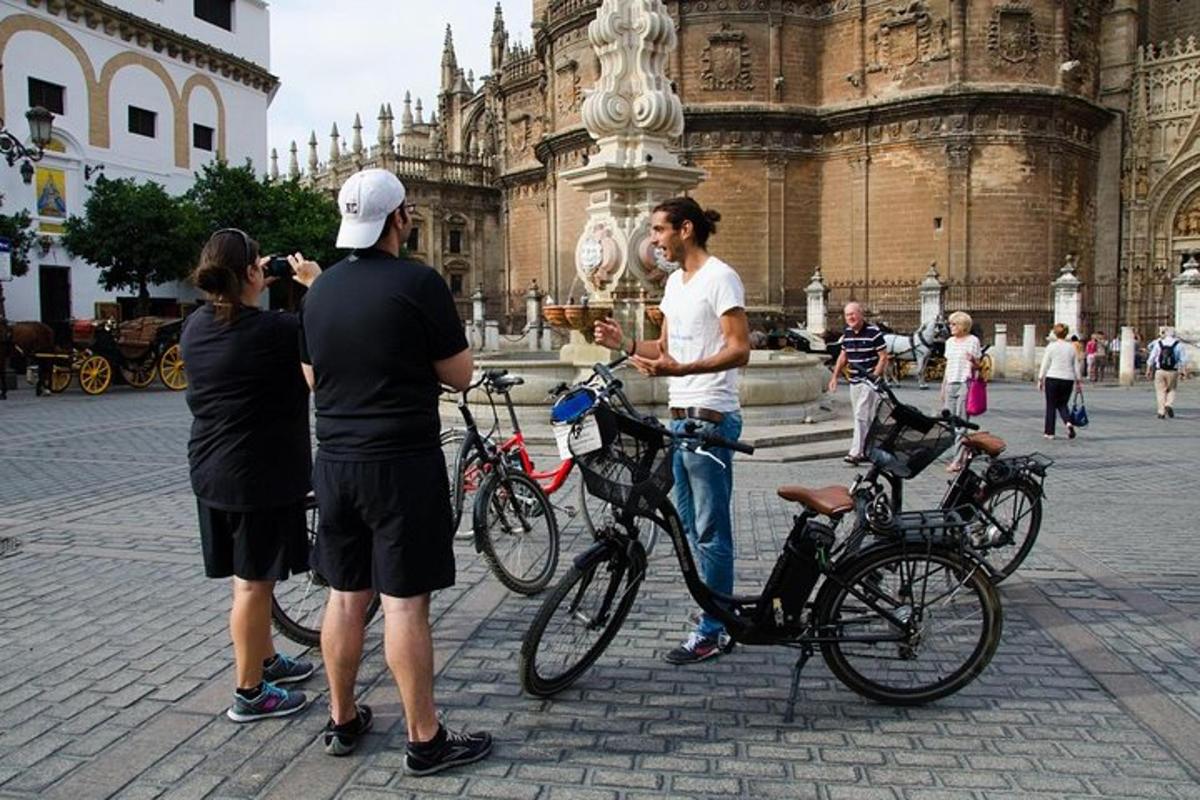 a group of people standing with bikes in front of a building