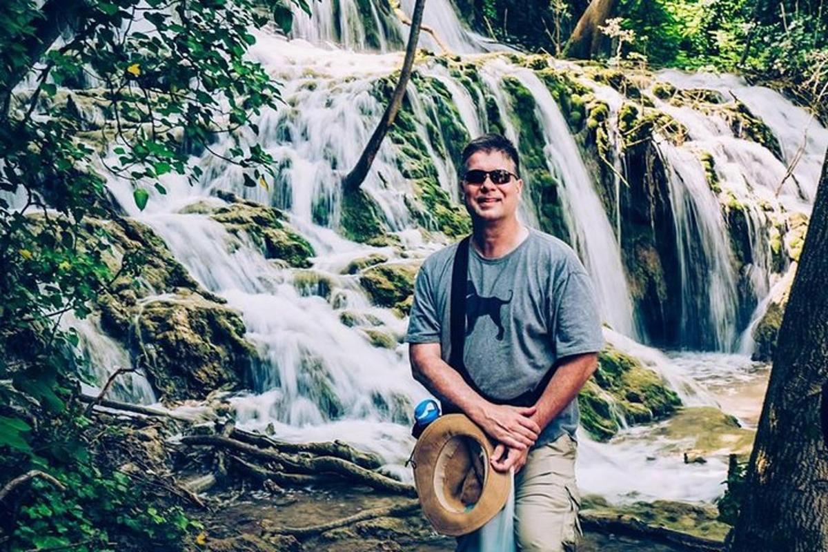 a man standing in front of a waterfall