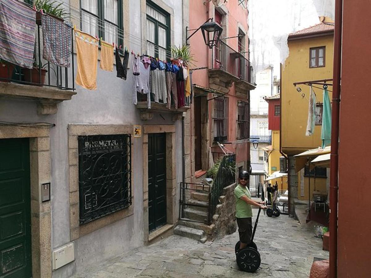 un uomo che cammina lungo un vicolo con una valigia