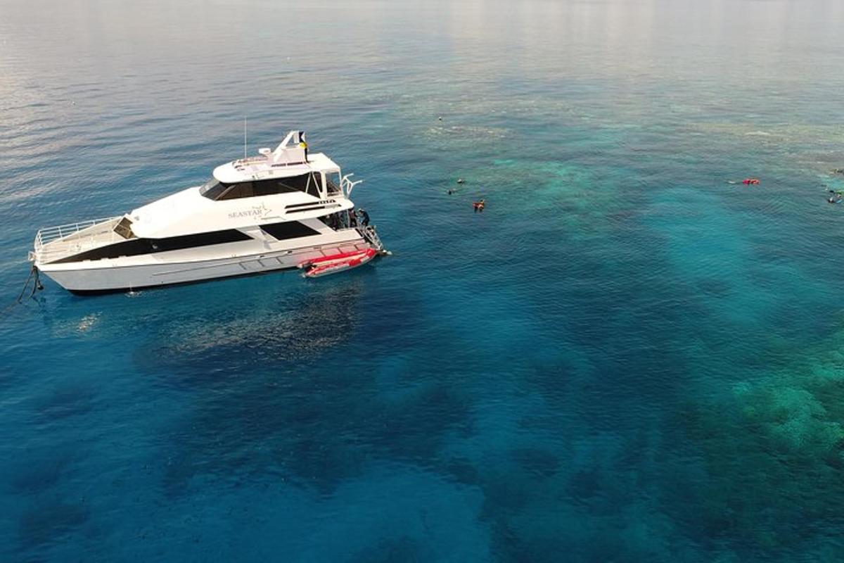 a white boat in the water with a reef