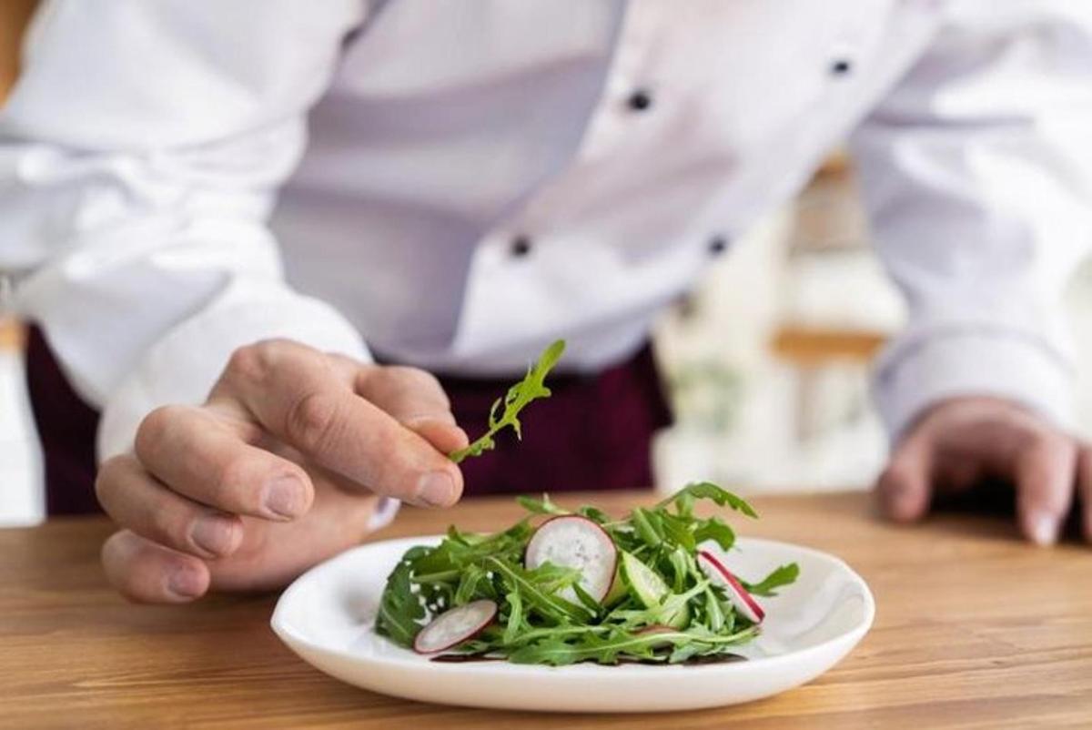 a chef eating a plate of food on a table