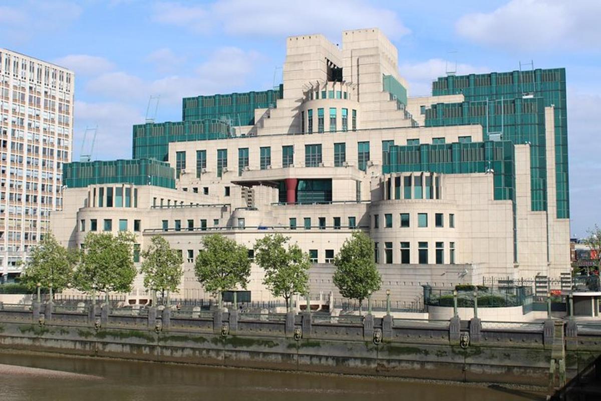 a large white building next to a river with buildings
