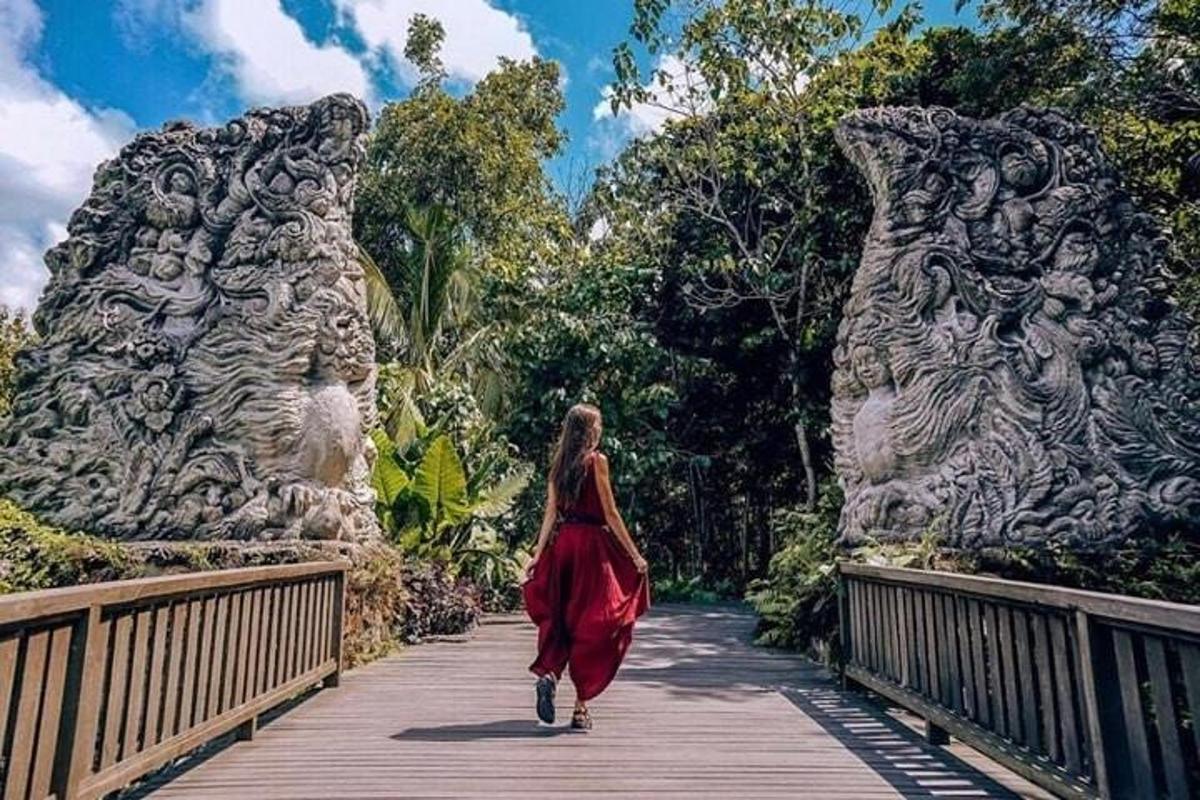 a woman in a red dress walking across a bridge