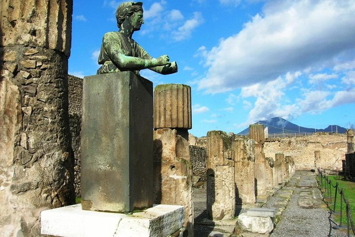 una estatua de una mujer sentada en lo alto de un edificio