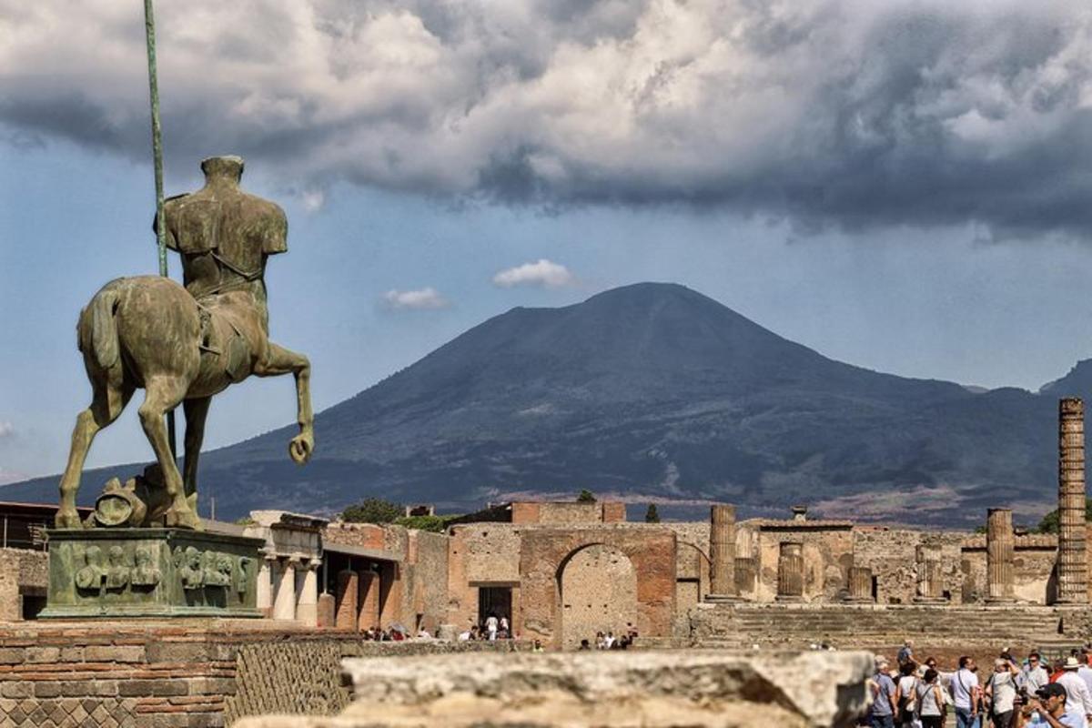 Una estatua de un hombre montado a caballo con una montaña al fondo.