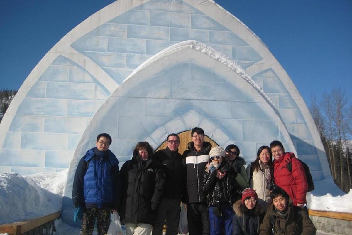 a group of people standing in front of an igloo
