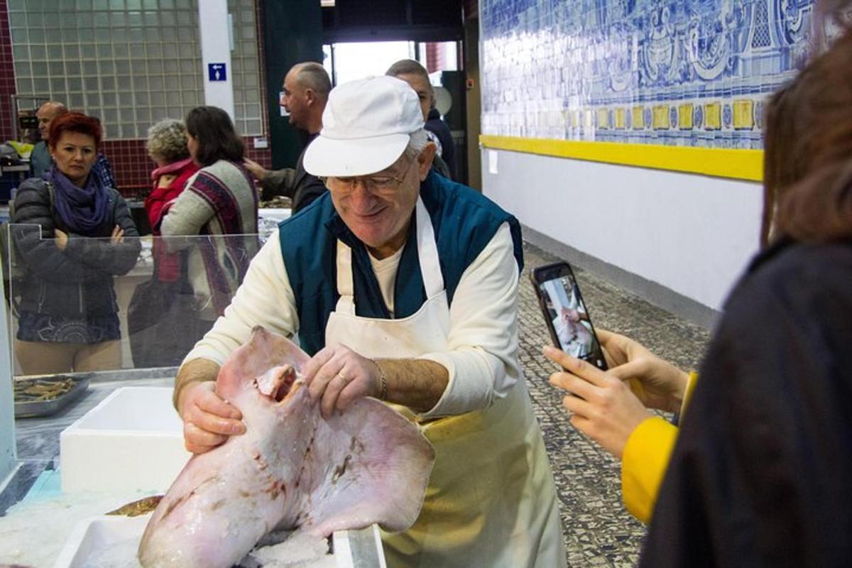 ženska fotografira moškega, ki drži prašiča