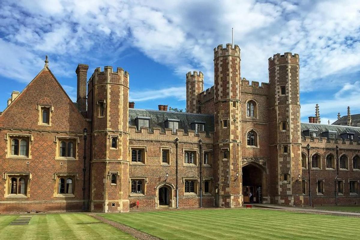 a large brick building with a grass field in front