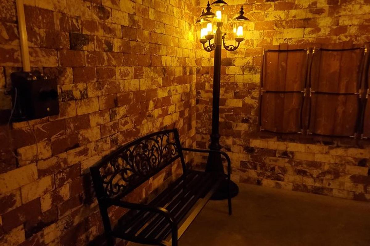 uma luminária colocada ao lado de um banco próximo a uma parede de tijolos