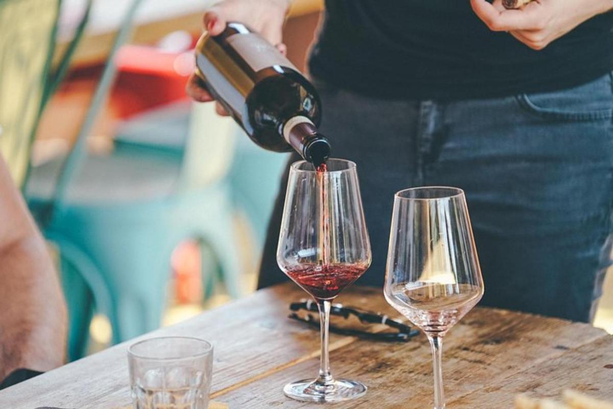una persona che versa il vino in due bicchieri da vino su un tavolo